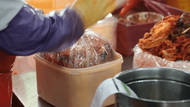 김치가 플라스틱 용기에 포장되는 모습