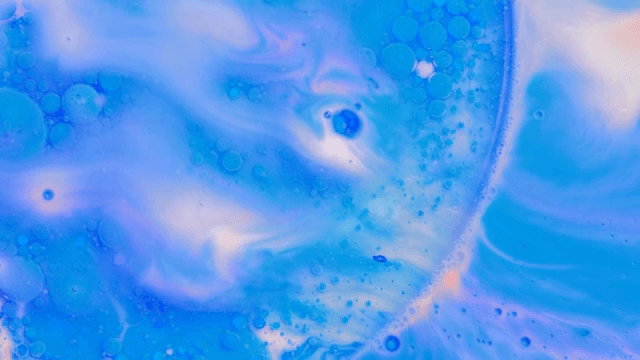 Abstract pattern of blue and purple liquids mixing together