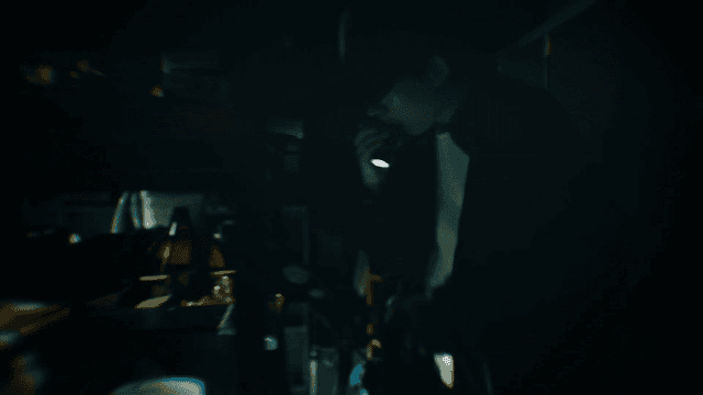 Man rummaging through bags in dark warehouse