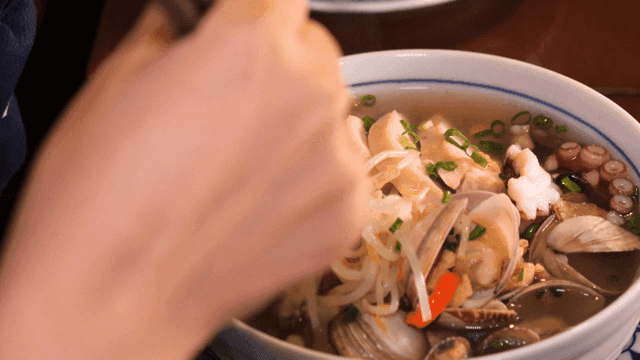 Chopsticks scooping up seafood rice noodles