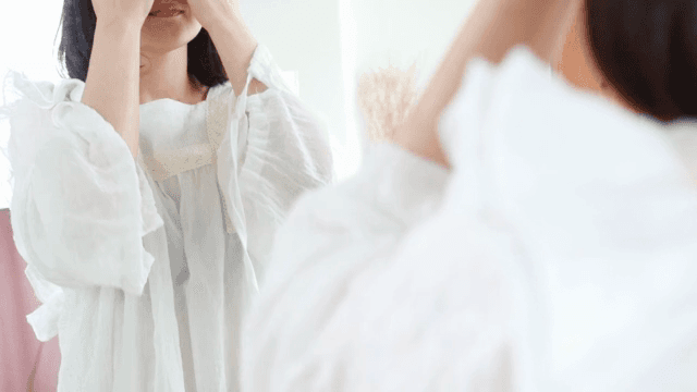 거울 앞에서 스킨케어를 하는 여성