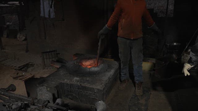 Worker working with molten metal in a foundry