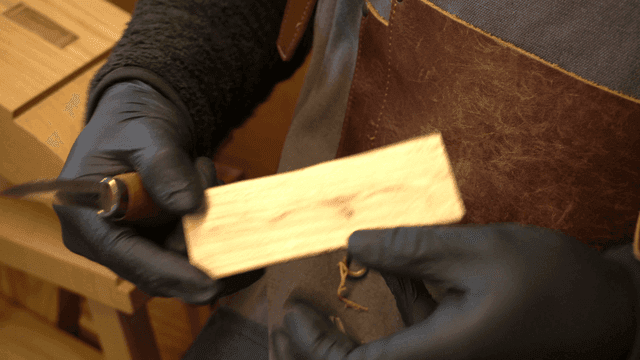 장인이 칼로 정교하게 나무를 조각하는 모습