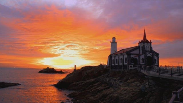 고요한 성당 세트장이 있는 바닷가 하늘을 물들이는 노을