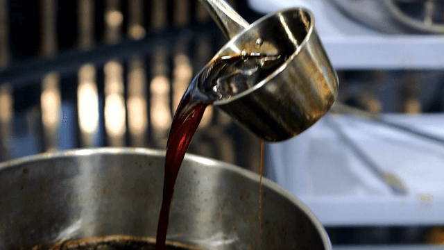 Black seed broth being stirred in a pot