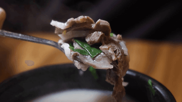 Spoonful of beef soup with vegetables