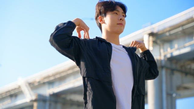 Man stretching outdoors under a bridge