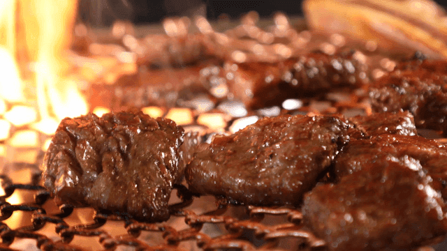 Sizzling grilled beef short ribs on barbecue