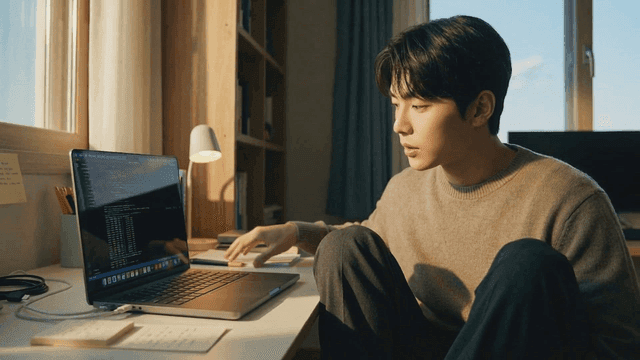 Person concentrating on coding at desk