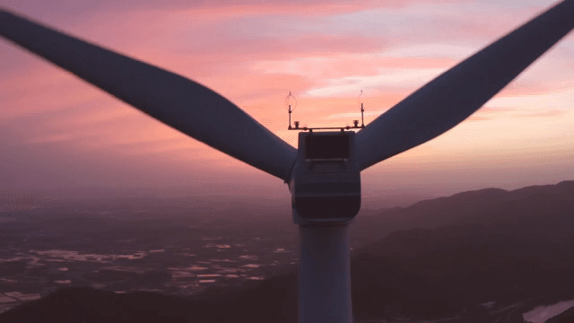 핑크빛으로 물들은 하늘 아래 산악 지역의 풍력 터빈