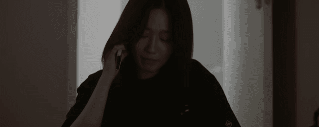 방에서 짐을 챙기며 통화하는 여성