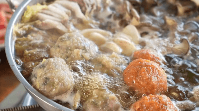 A pot of Korean hot pot with dumplings