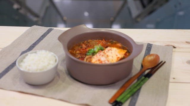 Mustard leaf kimchi stew and rice on a table