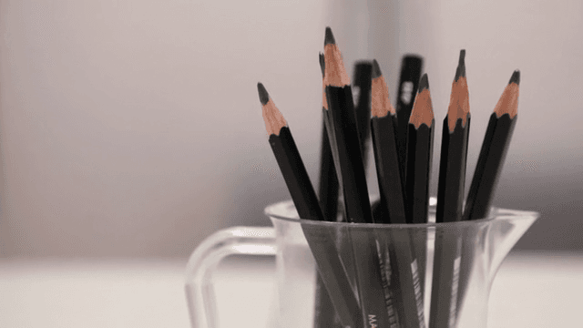 책상 위 투명한 컵에 담긴 연필들