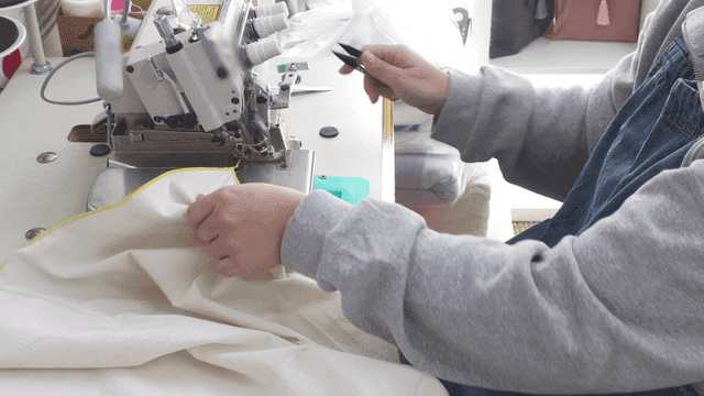 Person sewing fabric with a machine