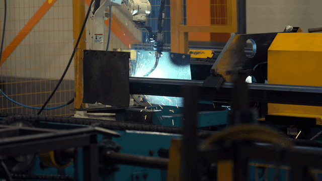 공장에서 금속을 용접하는 로봇 팔