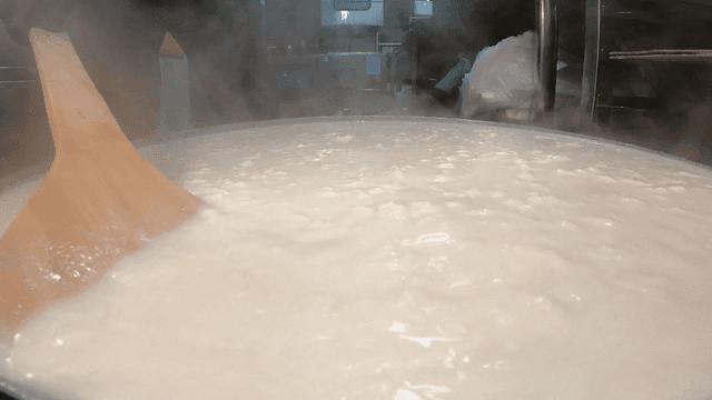 Hot soft tofu being stirred in large pot