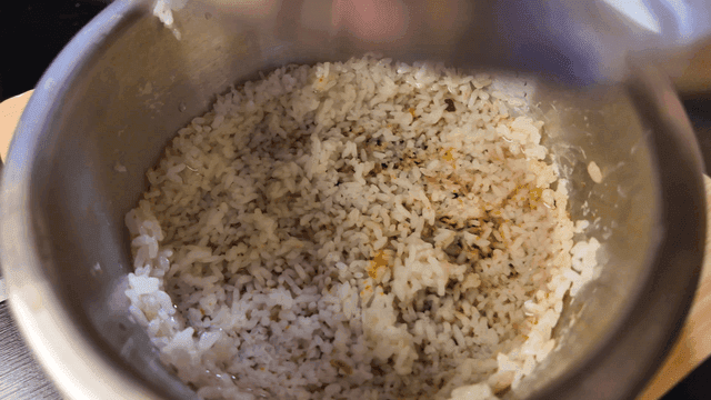 Hand closing lid on rice water for nutritious pot rice