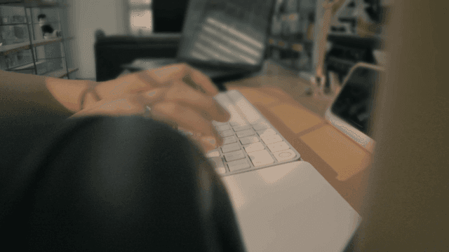 Hands typing on keyboard over headset