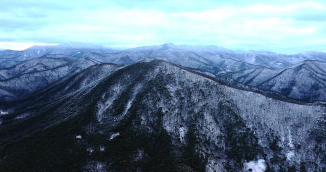 Snow-covered mountains under cloudy skies