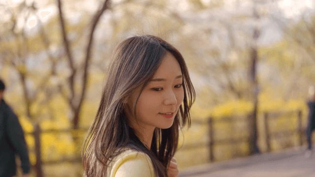 햇살 가득한 공원에서 손을 잡고 걷는 여성