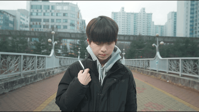 Young man walking on a city bridge