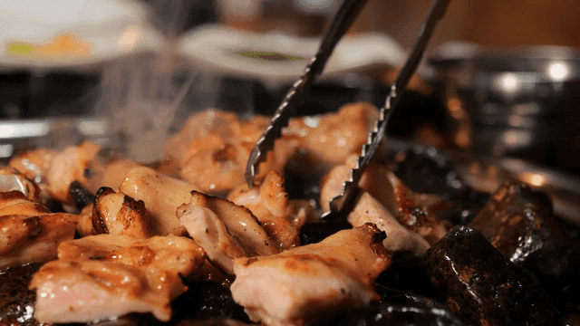 Charcoal-grilled chicken galbi sizzling on hot stone