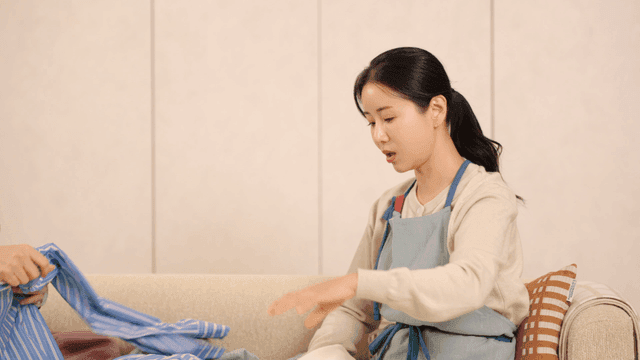 Woman folding laundry on a sofa