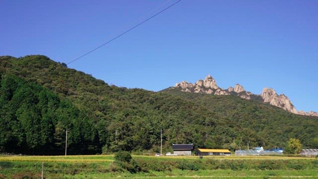 Farmhouses with mountain range under clear blue sky