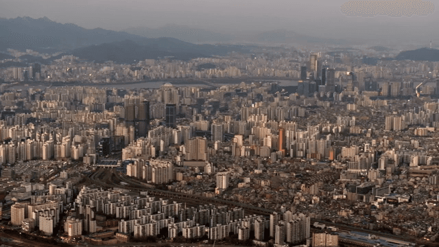 Sprawling cityscape with distant mountains at sunset