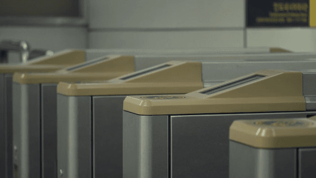 People passing through subway turnstiles