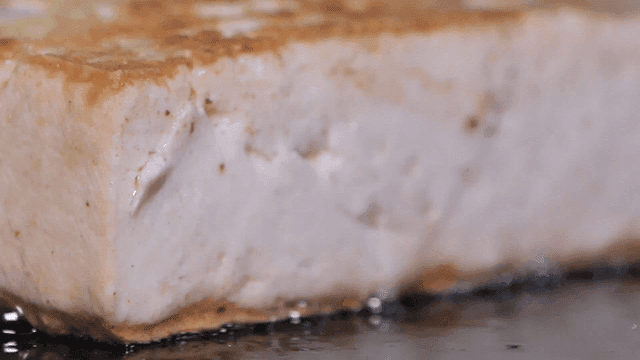 Tofu being fried on a hot pan