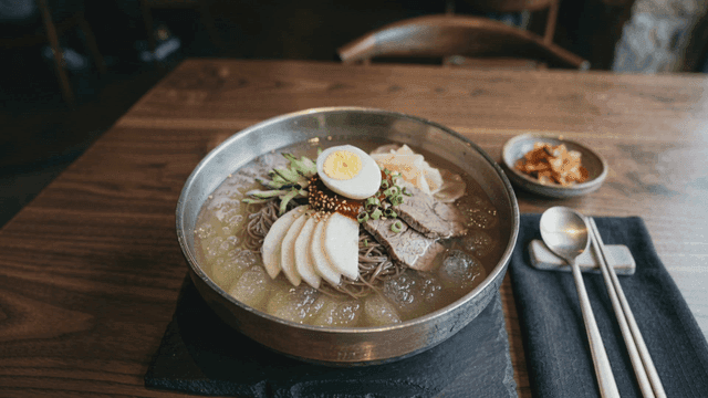 Bowl of cold noodles served with side dishes