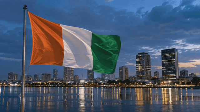 Night view of city skyline and flag of Côte d'Ivoire