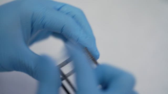 파란 장갑을 끼고 샘플 작업 중인 과학자