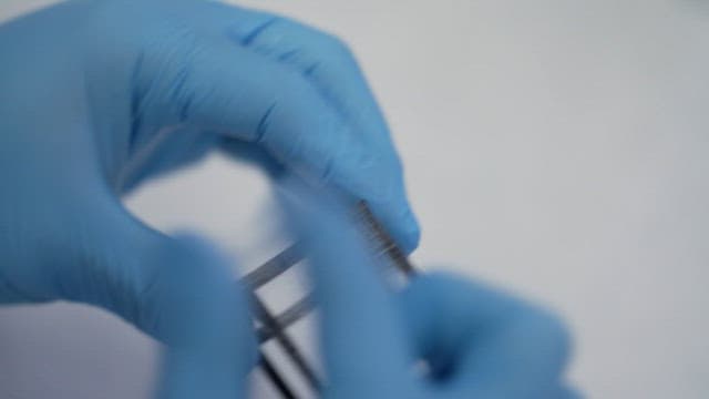 Scientist wearing blue gloves working on a sample