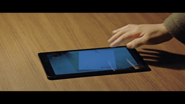 Hand interacting with a tablet on a table