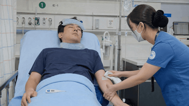 Nurse caring for patient with high fever at hospital