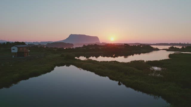 Sunset over a serene landscape with distant mountain