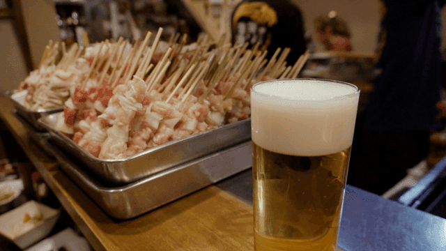 카운터 위의 꼬치와 맥주 한 잔