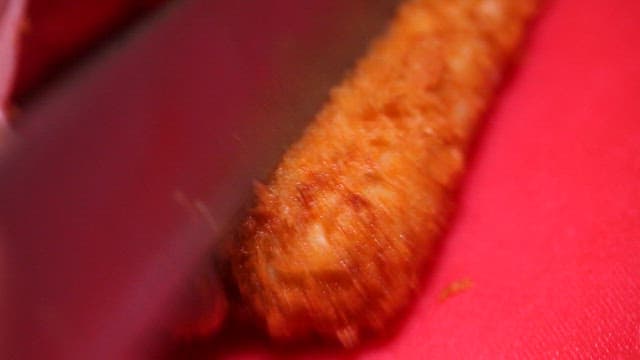 Cheese-filled pork cutlet being sliced