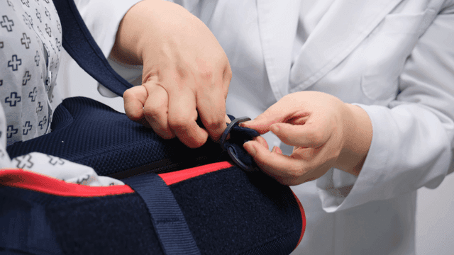 Doctor adjusting patient's medical aid strap