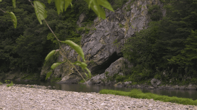 Quiet river flowing beside rocky cliff