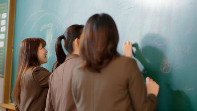 Students scribbling on a classroom blackboard