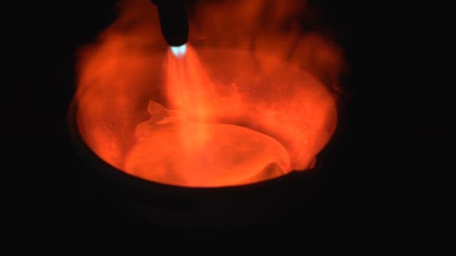 Molten metal being heated with a torch