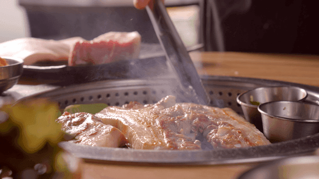 Grilling pork belly on a tabletop grill