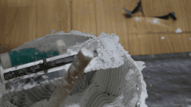 Bucket of adhesive with a mixing tool