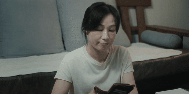 스마트폰을 보며 한숨을 내쉬는 여성