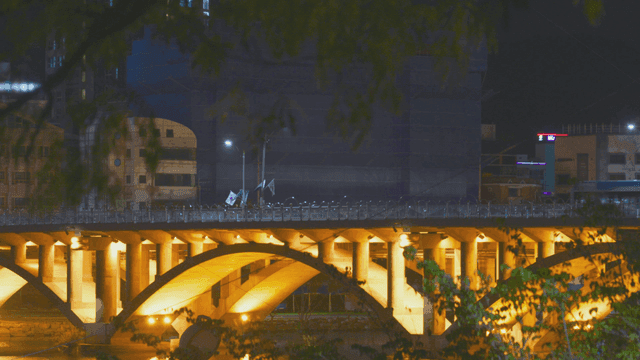 밤에 번화한 도시의 조명이 켜진 다리