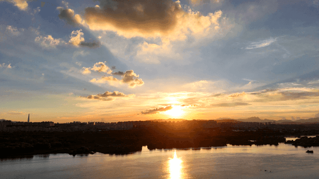 Sunset over a city skyline and river